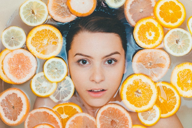 Kobieca twarz z pomarańczami