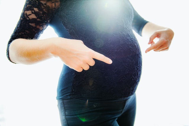 Kobieta w ciąży wskazująca na swój brzuch